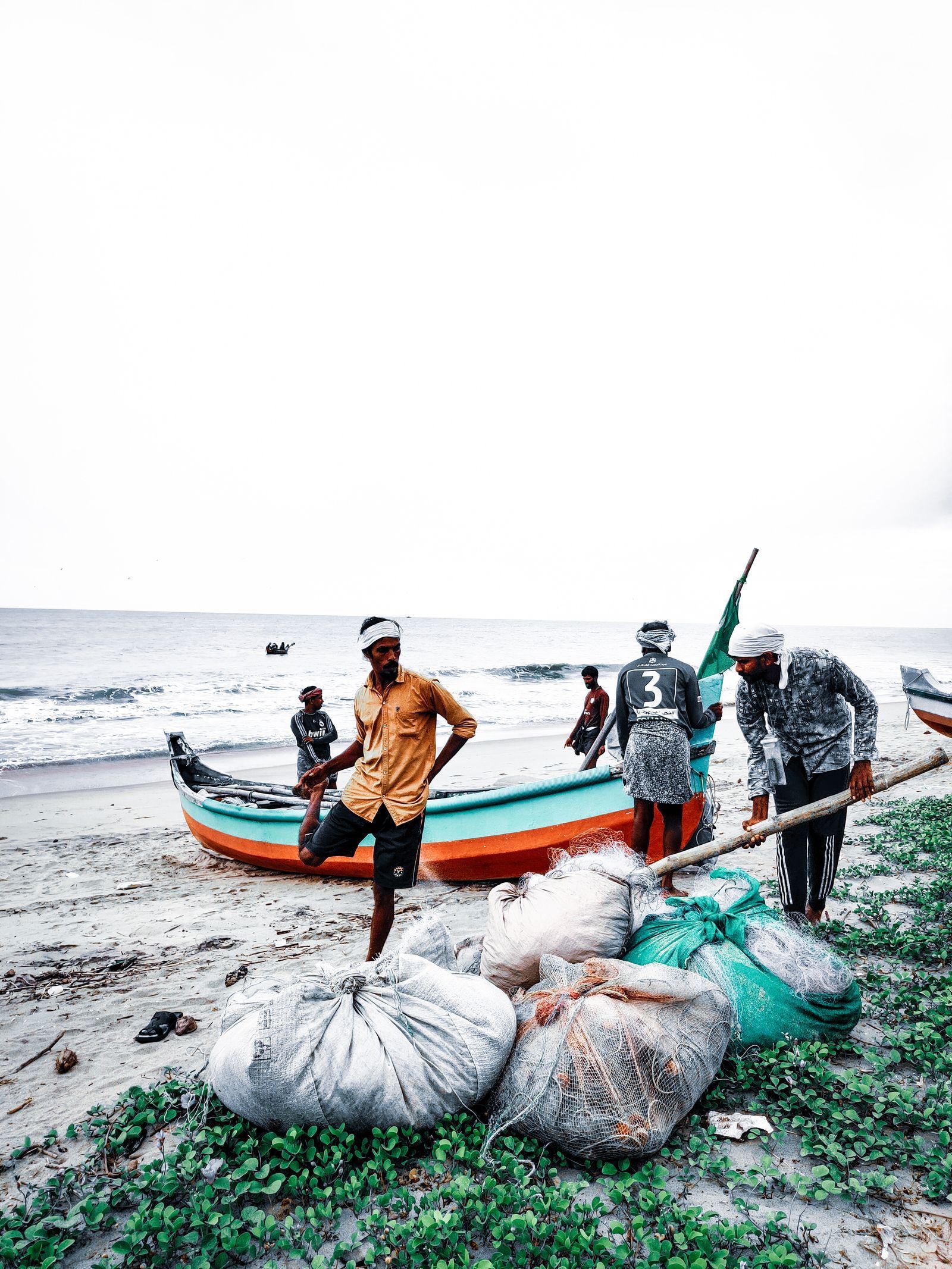 Fishermen in Kerala unloading the day's catch from a boat on the beach